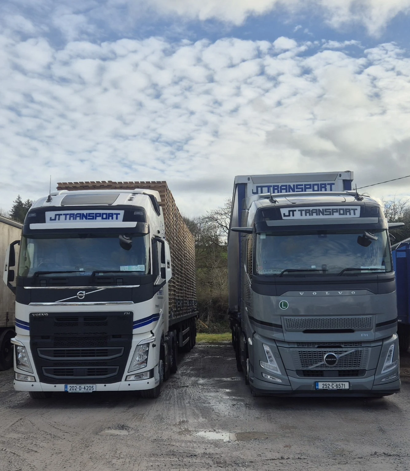 Two JT-branded trucks photographed together.