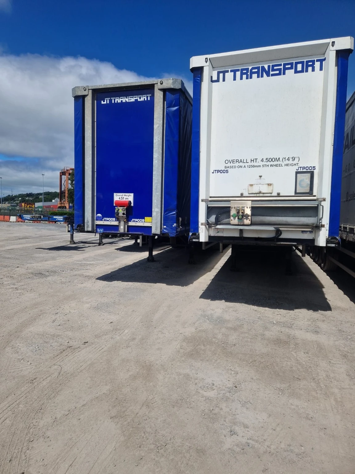 JT-branded curtainsider trailers parked in the yard.